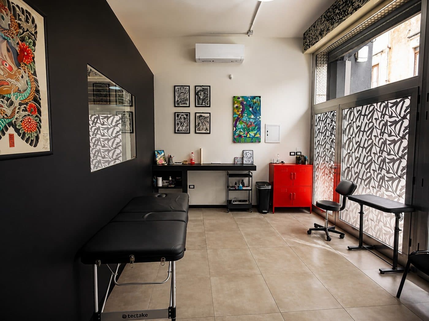 Sala tatuaggi con lettino e vetrata dello studio DEAR'S HOOD